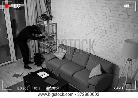 Top View Of Stealthy Disguised Criminal Searching Cash Or Important Papers, Holding Book, Black And 