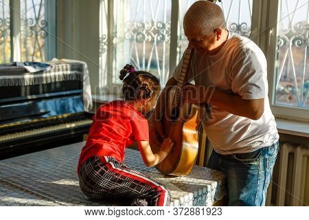 Closeup Mans Hand Changing Strings On His Old Acoustic Guitar.