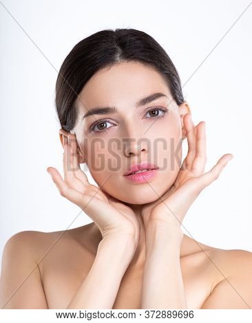 Portrait of beautiful young brunette woman with clean face. Beautiful face of young adult woman with clean fresh skin - isolated on white. Front portrait of woman with beauty face. Beauty concept 