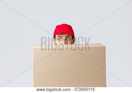 Packages And Parcels Delivery, Covid-19 Quarantine And Transfer Orders. Scared Courier In Red Unifor