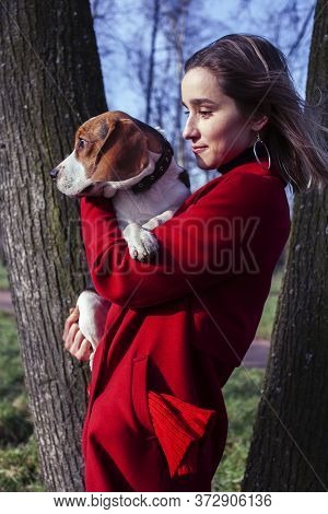 Pretty Young Girl In Redd Coat Playing With Dog Outside In Green Park, Lifestyle People Concept