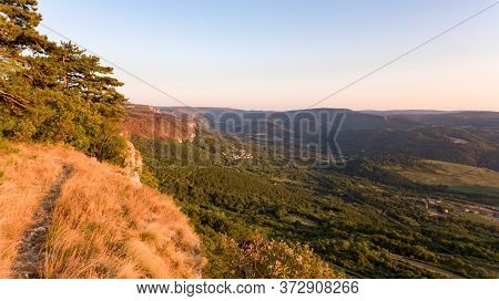 Aerial View Of Forest Gorwing Right To The Edge Of A Sheer Cliff.