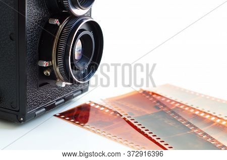 Old photo camera with negatives and photos taken to remember old times