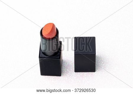 Red Lipstick Isolated. Close-up Of A Sexy Orange Lipstick With Glamorous Shiny Glittering Gold On A 