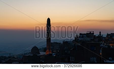 Mardin, Turkey - January 2020: Mardin Cityscape At Sunset With Minaret Of Ulu Cami, Also Known As Gr