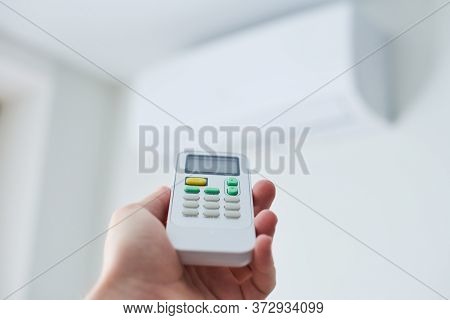 Air Condition Remote Control. Hand With Room Conditioner Remote Control. Air Temperature Switch For 