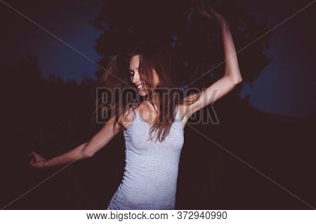Girl Is Dancing Extaticly In The Dark With Her Arms Raised, 90s Soap-box Style Philm Photo Imitation