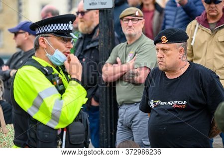 Richmond, North Yorkshire, Uk - June 14, 2020: A Police Officer Adjusts His Ppe Face Mask And Confro