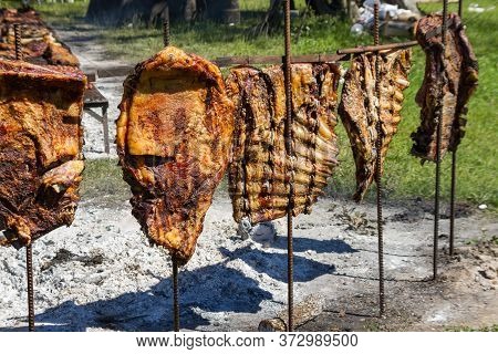 Cow Ribs To The Cross Roasting On The Coals, Typical Of The Argentine Countryside