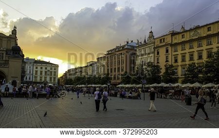 Krakow, Poland - May 23, 2014: A Street View Of Touristic Main Square At Sunset In The Center Of Kra