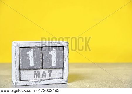 May 11, On Calendar Made Wood Painted In Gray And White, Yellow Background