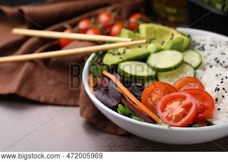 Delicious Poke Bowl With Vegetables, Avocado And Mesclun On Textured Table, Closeup