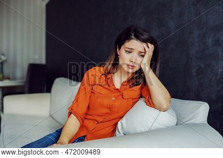 Sad Woman Leaning On Sofa And Overthinking. Solitude Is Worst Enemy.