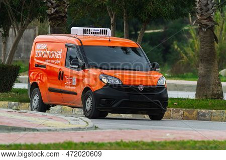 Side, Turkey -february  27, 2023:   Orange Fiat Doblo     Is Driving Fast On The Street On A Warm  W