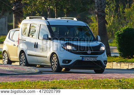 Side, Turkey -  January 31 2022:   White Fiat Doblo  Is Driving Fast On The Street On A Warm Summer 