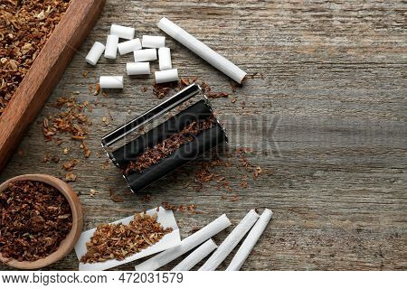 Flat Lay Composition With Roller And Tobacco On Old Wooden Table, Space For Text. Making Hand Rolled