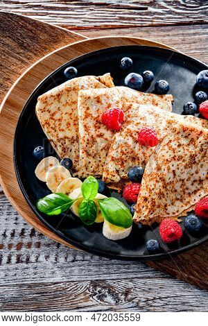 A Plate Of Pancakes With Cheese And Fruits