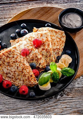A Plate Of Pancakes With Cheese And Fruits