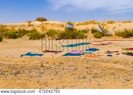 Tuareg  Women Dry Washed Clothers In Traditional Way. Colorful Laundry Drying In The Sun On Sand. Ta