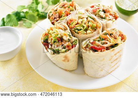 Tortilla Wraps With Chicken And Fresh Vegetables On Plate Over Light Background. Close Up View