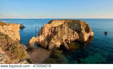 Small Islet And Grotto Near Praia Joao De Arens In Alvor. Algarve Region, Portugal