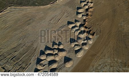 Arial View Of Open Pit Sand Mine. A Front Loader Loads Sand From Piles. Heavy Mining Machinery Worki