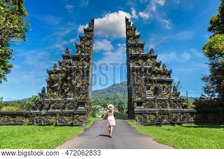Woman Traveler At  Bali Handara Gate In Bali, Indonesia In A Sunny Day