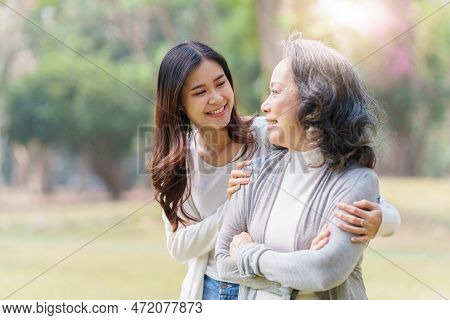 Portrait Of An Adult Daughter With Her Elderly Mother With Hug And Happy Moment