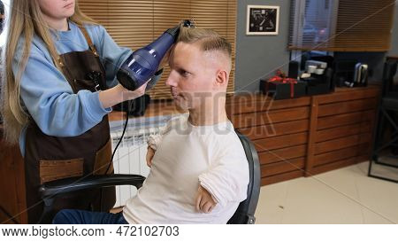 A Hairdresser Girl In A Beauty Salon Does Hair Styling For A Man With Disabilities.
