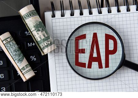 Letters Eap (employee Assistance Program) Under A Magnifying Glass On A White Notebook Against The B