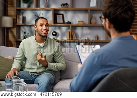 Visiting A Psychologist A Man Sits On A Couch And Talks To A Psychotherapist. He Thanks The Doctor A