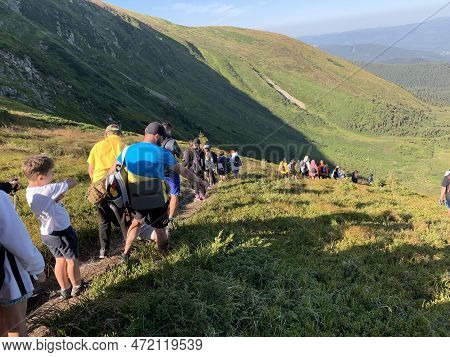 A Group Of Travelers In The Summer Against The Backdrop Of The Mountains. Youth Camp In The Carpathi