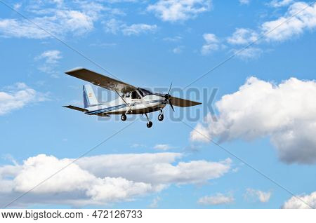 Single Engine Ultralight Plane Flying In The Blue Sky With White Clouds