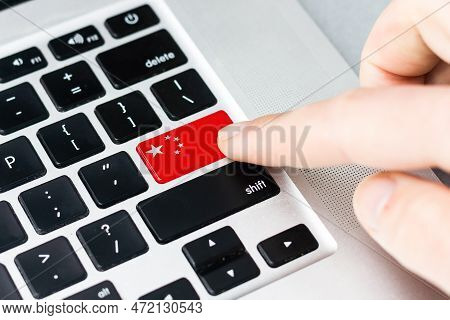 Online International Business Concept: Computer Key With The China Flag On It. Male Hand Pressing Co
