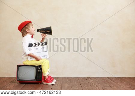 Newsboy Shouting Through Loudspeaker Against Grunge Wall Background. Kid Selling Newspaper. Child We