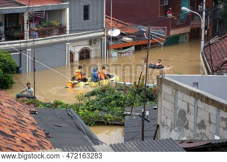 Jakarta, Indonesia - January 18, 2014 : Jakarta Resident Across The Flooding Street With Rubber Boat