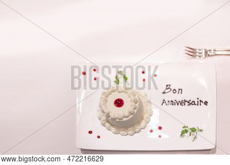 Small White Cake On A Dinner Plate Decorated With Strawberry Sauce And Mint Leaves With Happy Birthd