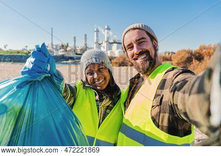 A Environmental Activist Or Volunteer Multiracial Couple Picking Up Trash Og The Beatch, And Taking 