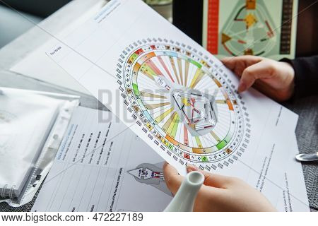 Tver, Russia - February 12, 2023: A Woman At The Table Is Studying A Rave Mandala By Human Design. R