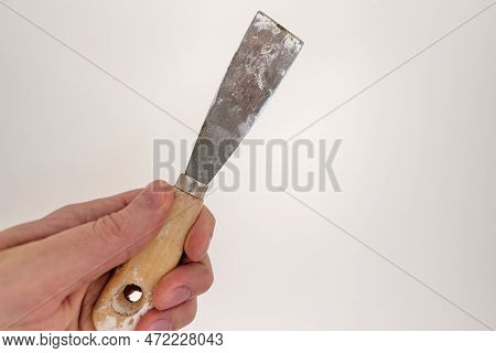 Holding steel painting spatula in a hand on white background, being ready for professional or d.i.y.