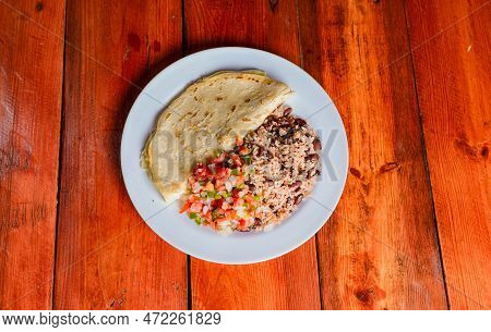 Quesillo Dish With Gallo Pinto And Pico De Gallo On Wooden Table. Nicaraguan Food Gallo Pinto With P