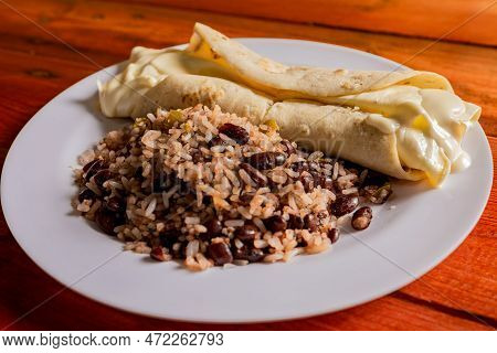 Traditional Gallo Pinto With Quesillo Served On Wooden Table. Nicaraguan Gallopinto With Quesillo On