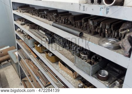 Metal Rack With Drills Blanks In Lathe Shop. Industrial Background. Turnery..