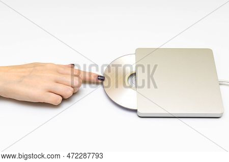 Woman Inserting A Laser Disc Into A Disk Drive. Hand Inserts Disk Into Drive.
