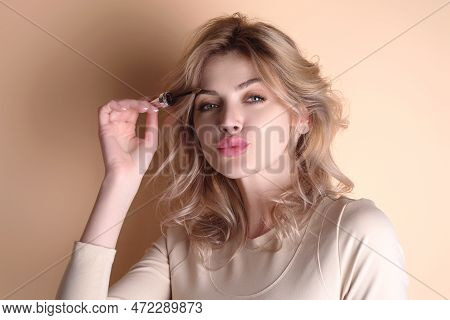 Beautiful Woman With Dark Eyebrows Hold Eyebrow Brush. Eyebrows Lamination. Brow Beauty Procedures. 