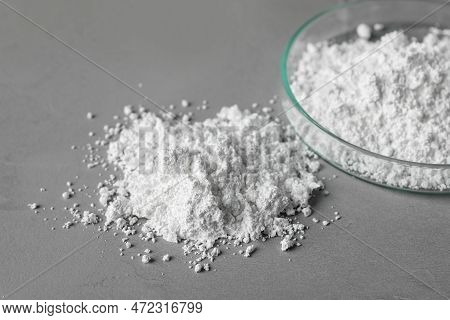 Petri Dish And Calcium Carbonate Powder On Grey Table