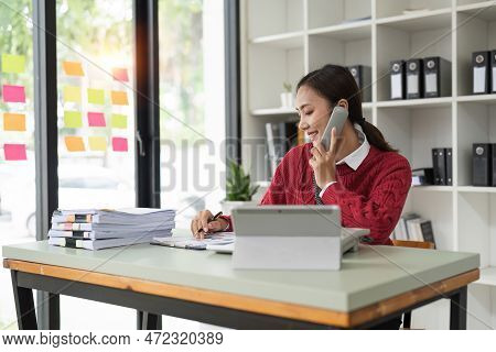 Beautiful Asian Woman Talking On Phone At Creative Office. Happy Smiling Businesswoman Answering Tel