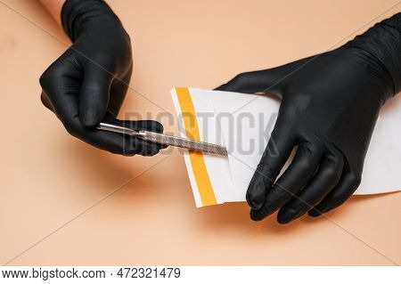 The Hands Of The Manicure Master Remove The Manicure And Pedicure Tools In A Sterilization Bag On A 