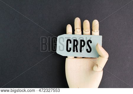 Wooden Hand Holding A Paper With The Letters Crps Or The Word Complex Regional Pain Syndrome