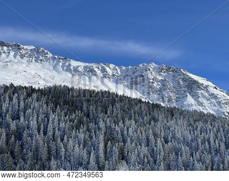 Beautiful Sunlit And Snow-capped Alpine Peaks Above The Swiss Tourist Sports-recreational Winter Res